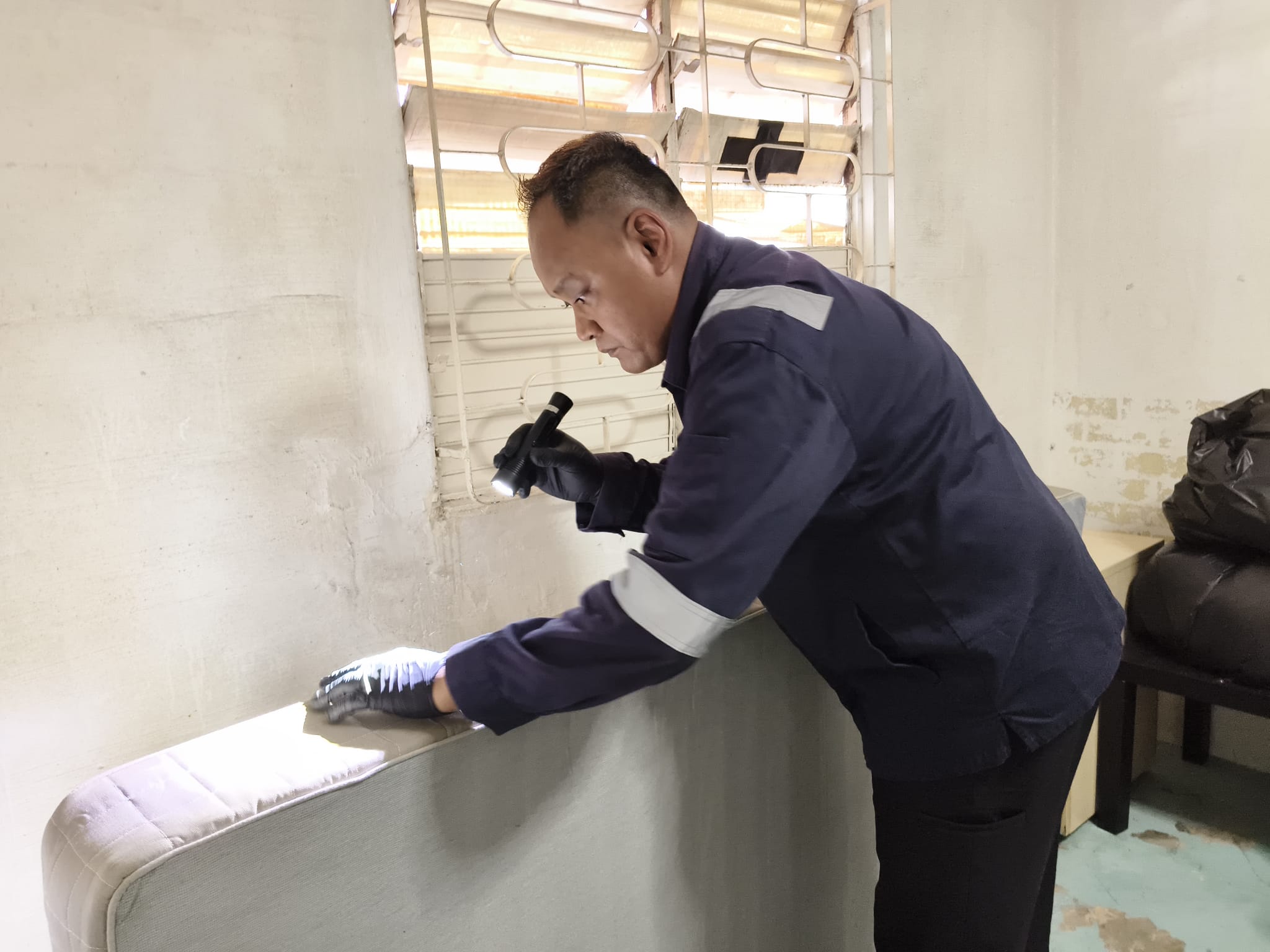 Person inspecting a mattress for bed bugs.